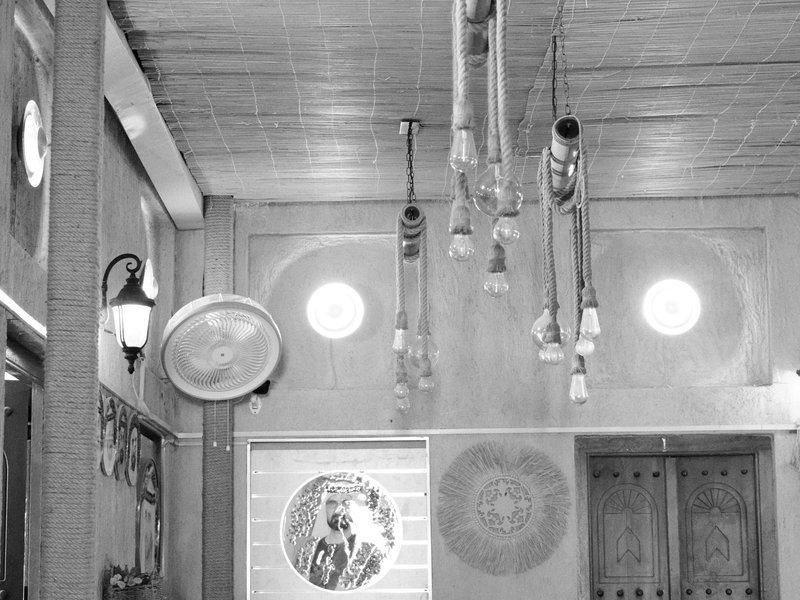 Interior of a room with hanging lights and circular windows, featuring a wall display.