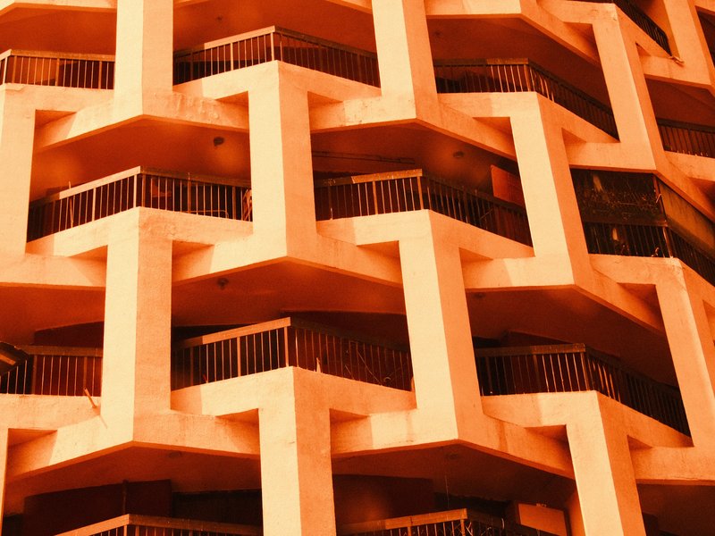 Close-up of a geometric building facade with zigzag patterns and balconies.