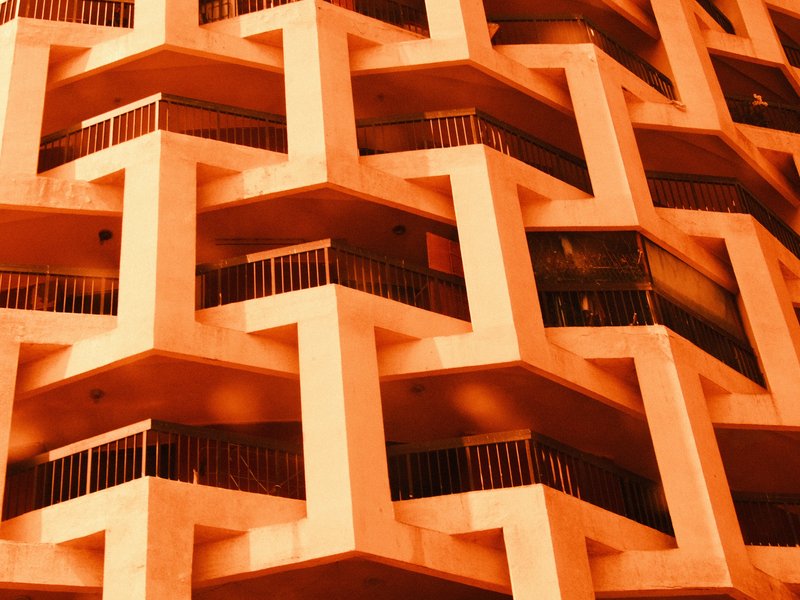 Close-up of a geometric building facade with zigzag patterns and orange tones.