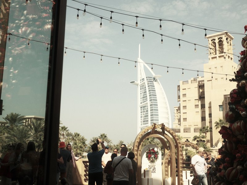 A wedding scene with guests and the Burj Al Arab in the background, decorated with lights.