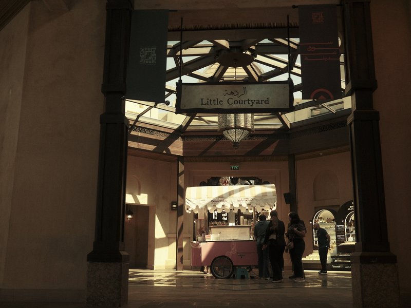 A vintage-style food cart in a spacious indoor area with high ceilings and decorative architecture.