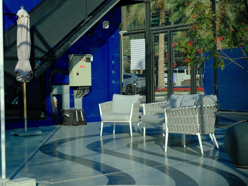 A modern indoor seating area with two white chairs and a blue wall backdrop.