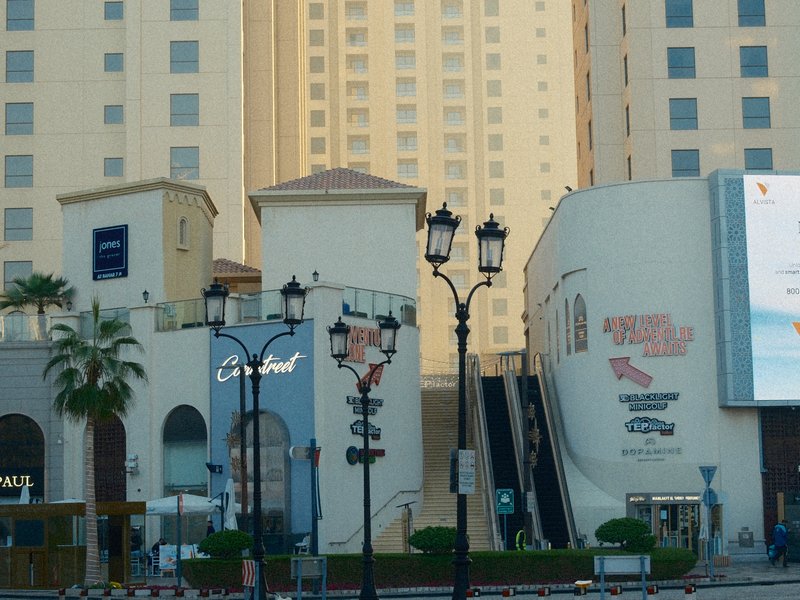 Urban scene featuring modern buildings and street lamps in a city setting.