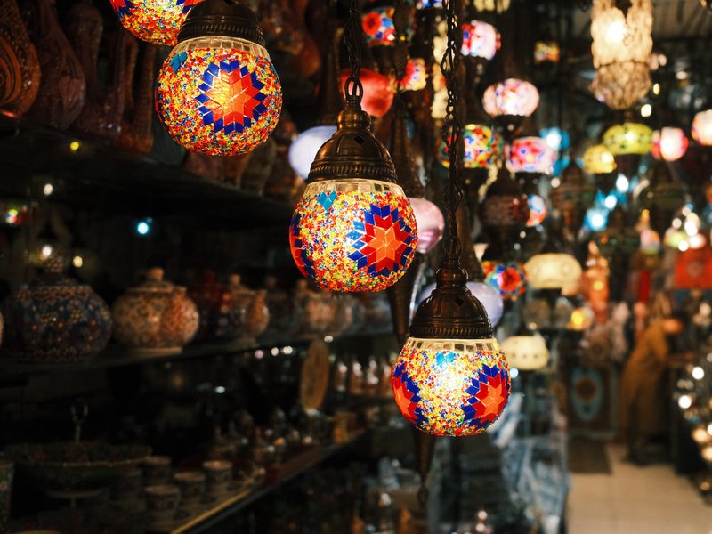 Colorful hanging lanterns in a dimly lit shop, showcasing intricate designs and warm light.