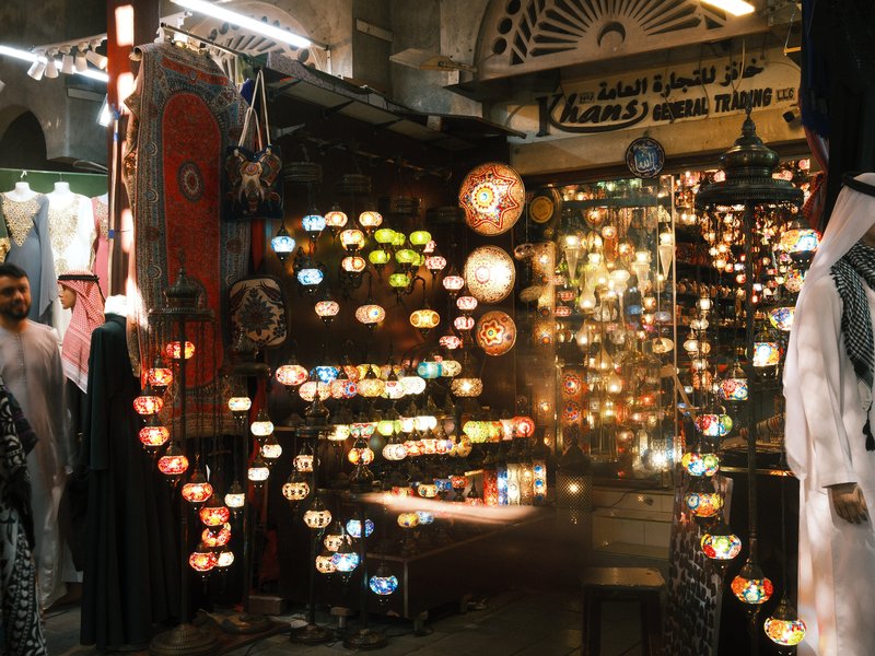 A vibrant market scene filled with colorful lanterns and lights, showcasing a bustling atmosphere.