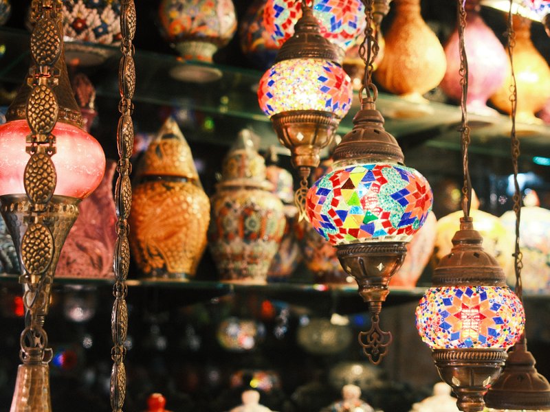 Colorful hanging lamps and decorative pottery displayed in a shop.