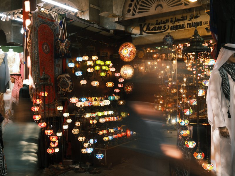 Colorful lanterns hanging in a market, with blurred lights creating a vibrant atmosphere.