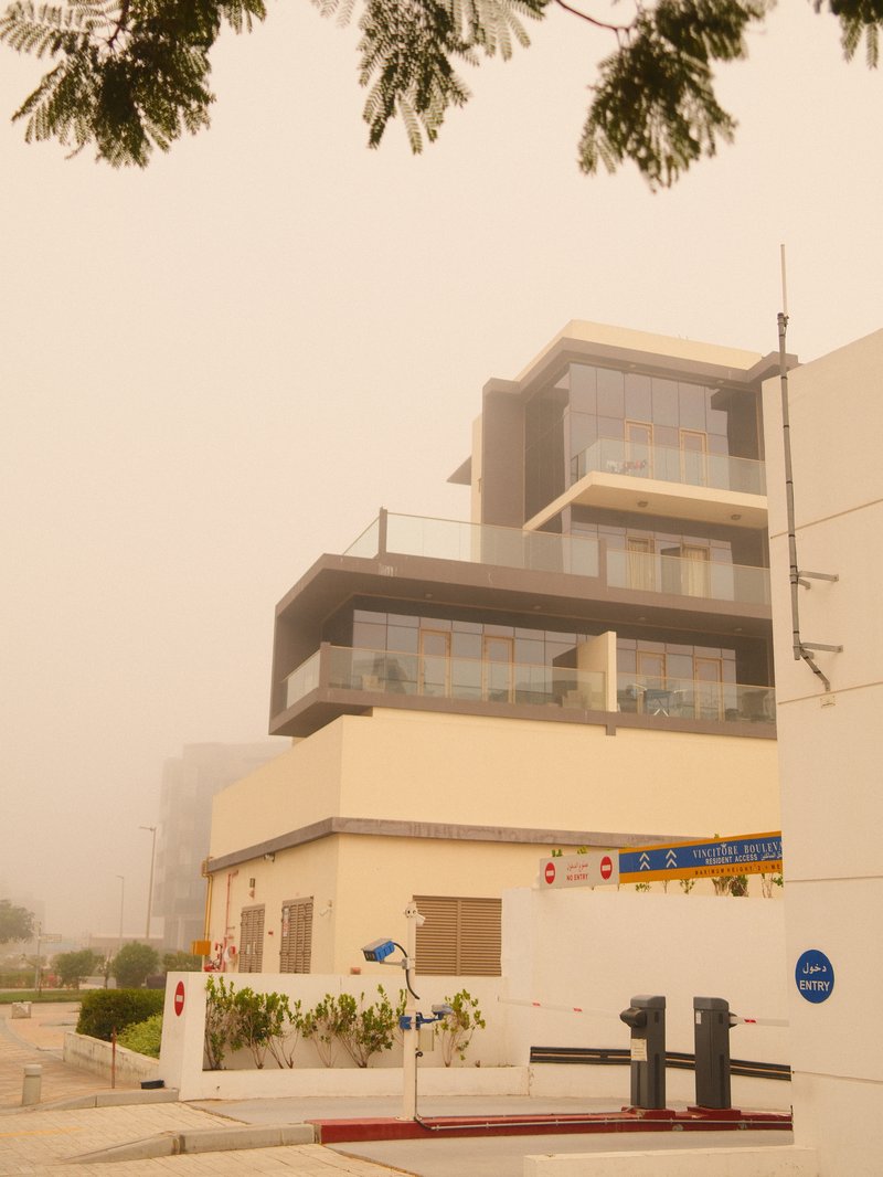 Modern building partially obscured by fog, with a muted color palette and urban surroundings.