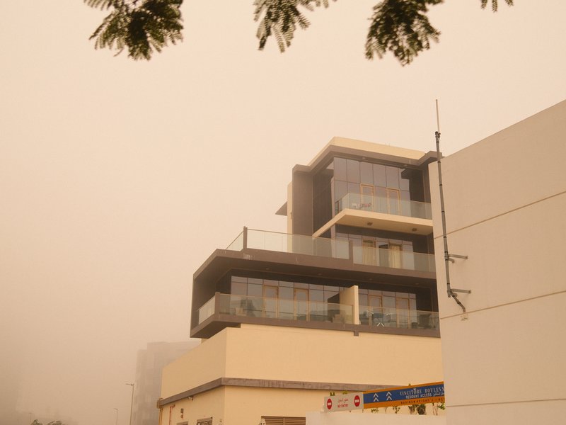 Modern building shrouded in fog with a muted color palette and soft outlines.