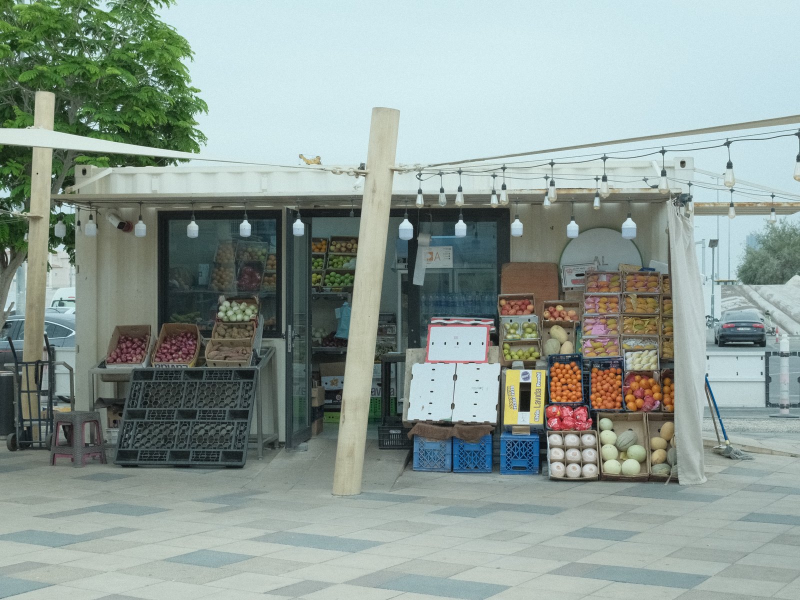 A fruit and vegetable market stall with colorful produce displayed outside a building.