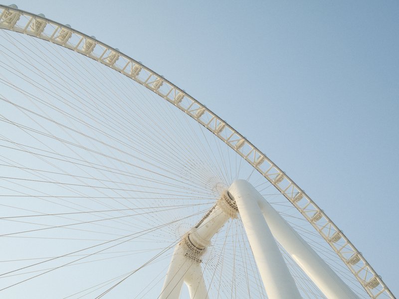 Close-up view of a large white ferris wheel against a clear blue sky.