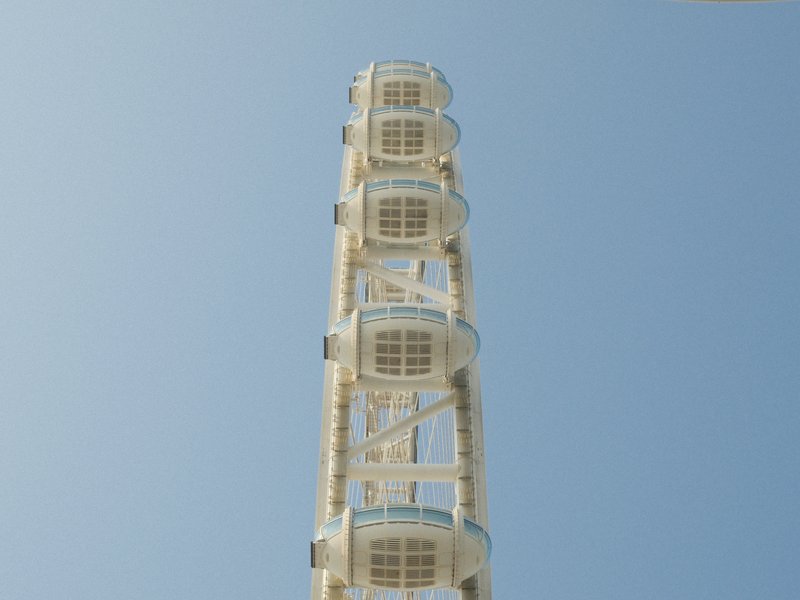 A tall white ferris wheel against a clear blue sky.