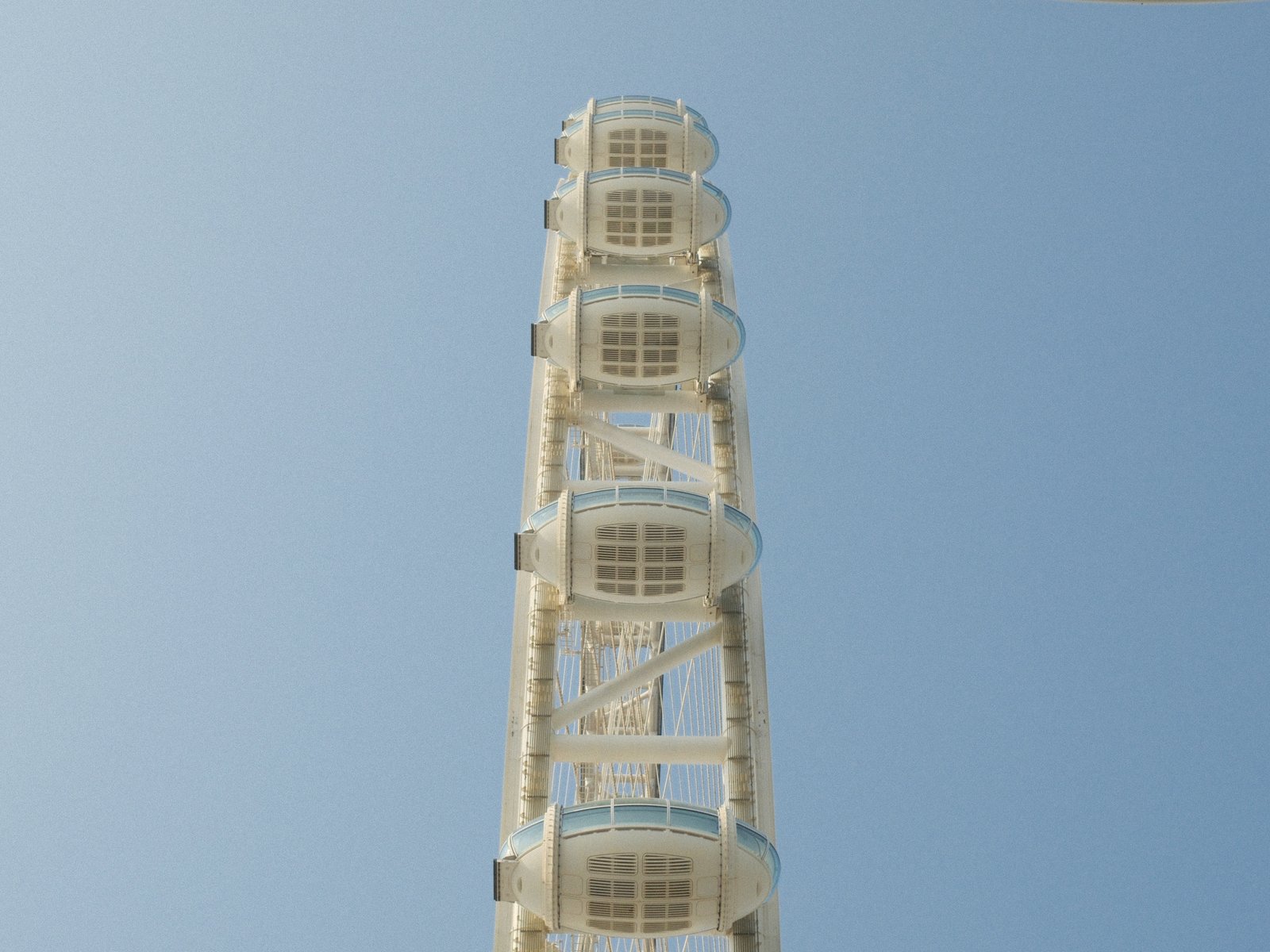 A tall white ferris wheel against a clear blue sky.
