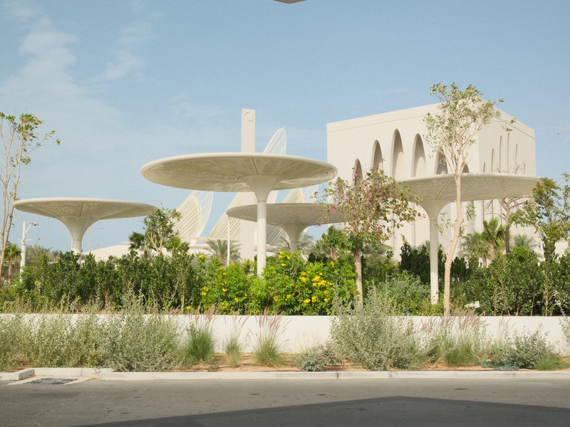 Modern architectural structures with large, circular canopies surrounded by greenery.