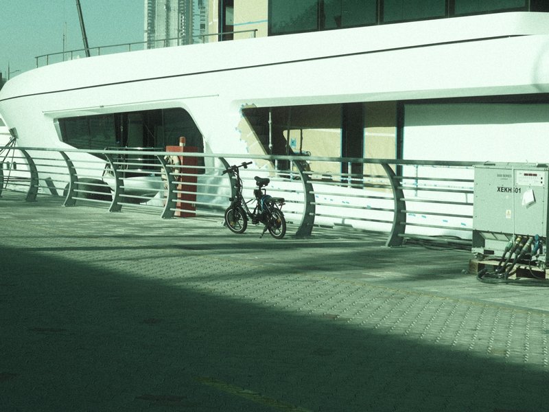 A bicycle parked near a modern white structure with a curved design and a railing.