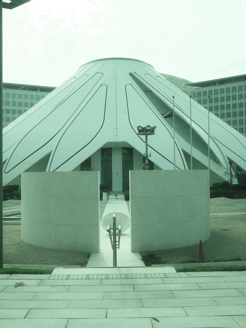 A modern architectural structure with a unique design, featuring a circular base and angular roof.