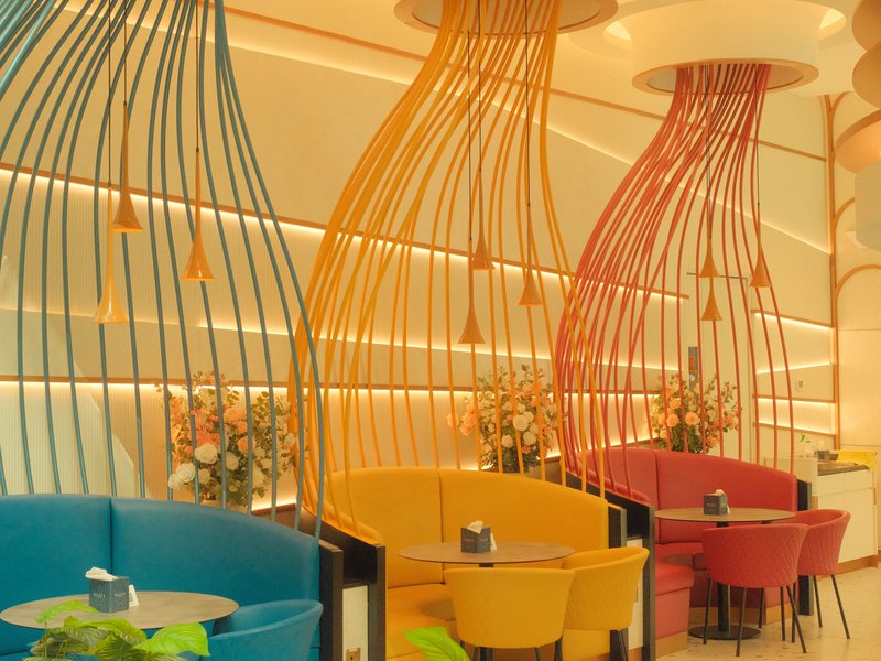 Colorful restaurant interior with unique hanging light fixtures and cozy seating arrangements.