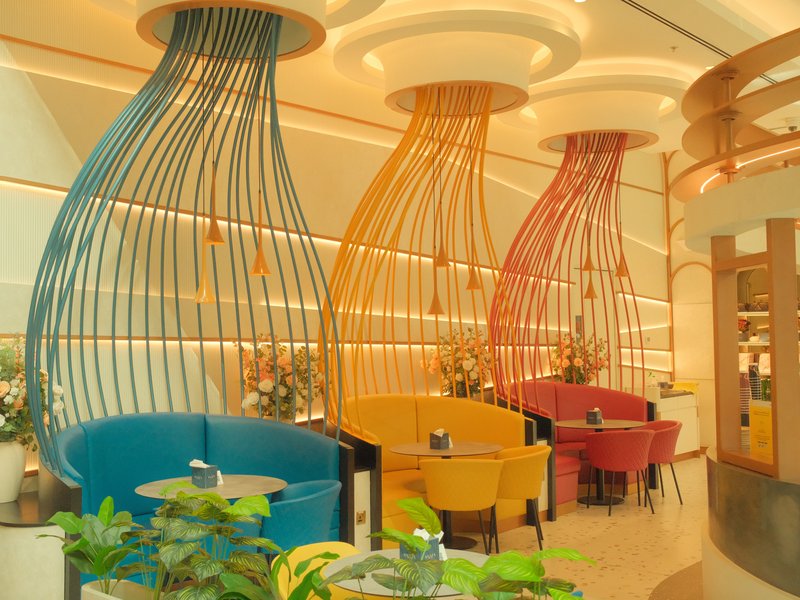 Interior of a modern restaurant featuring colorful seating and unique light fixtures.