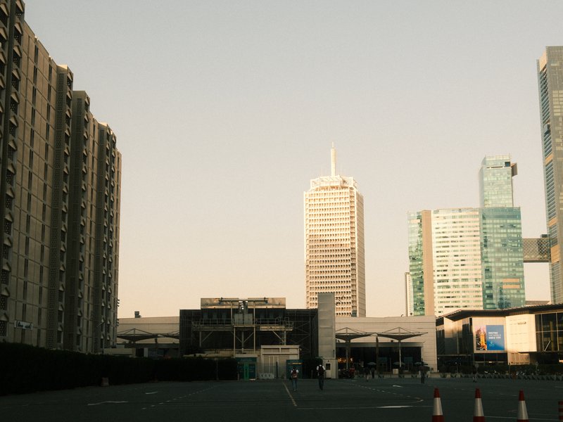 Urban skyline featuring modern buildings under a clear sky with a hint of sunset light.