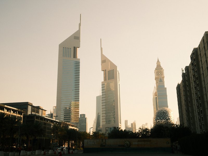 Silhouetted skyscrapers against a golden sunset sky in an urban setting.