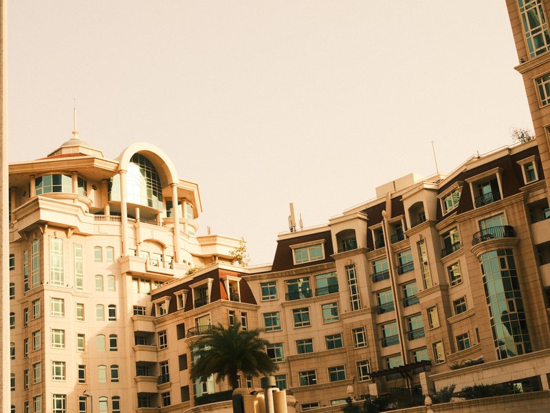 A modern building with a mix of architectural styles under a soft pastel sky.