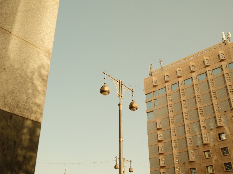 Urban scene featuring a street lamp and a modern building under a clear sky.