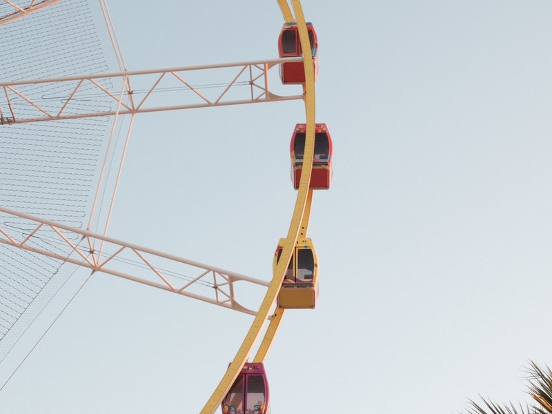 Close-up of a colorful ferris wheel against a clear sky.