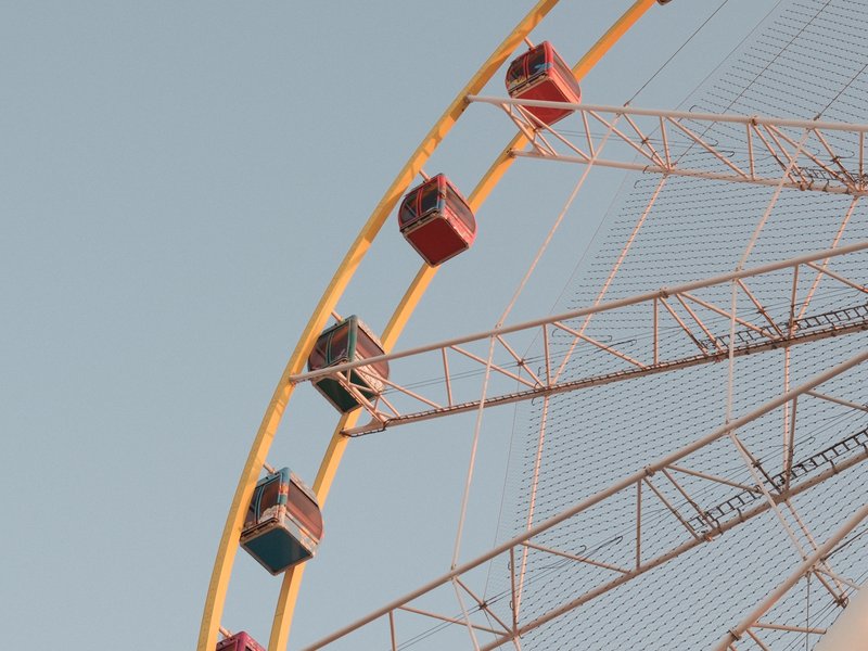Close-up of a colorful ferris wheel against a clear sky.