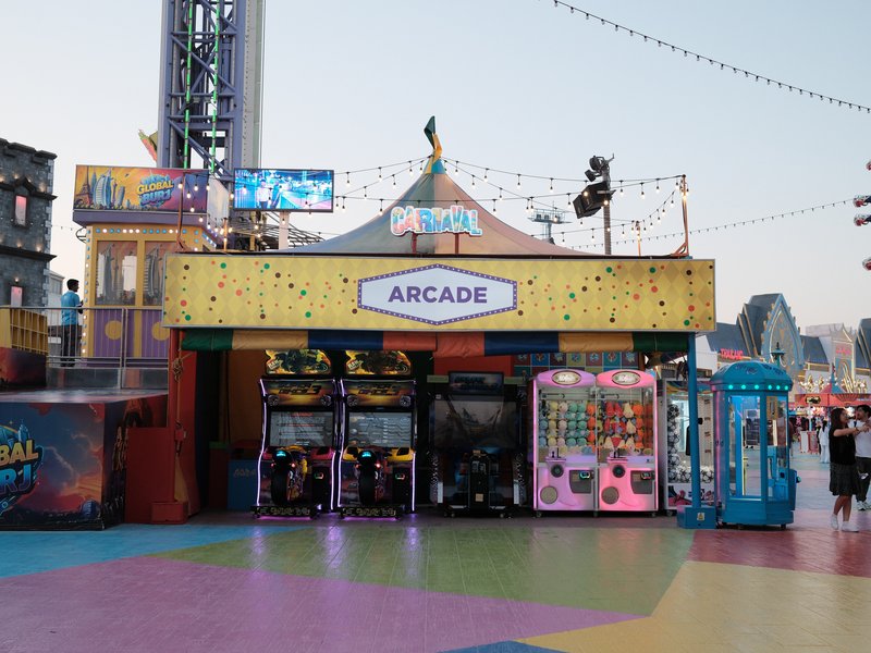 Colorful arcade entrance with games and bright signage in a festive outdoor setting.