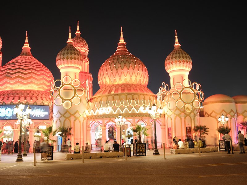 Colorful illuminated architecture resembling a fairytale castle at night.