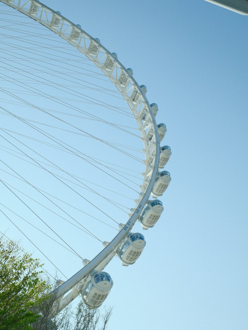 A close-up view of a large Ferris wheel against a clear blue sky.
