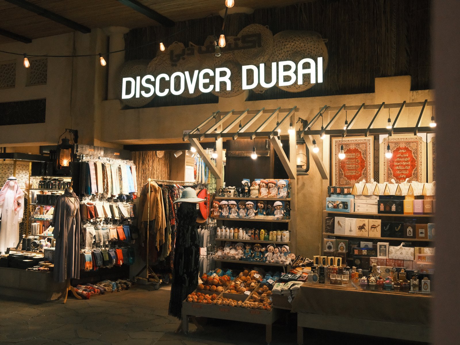 A shopfront displaying souvenirs and local products with a sign that reads 'Discover Dubai'.