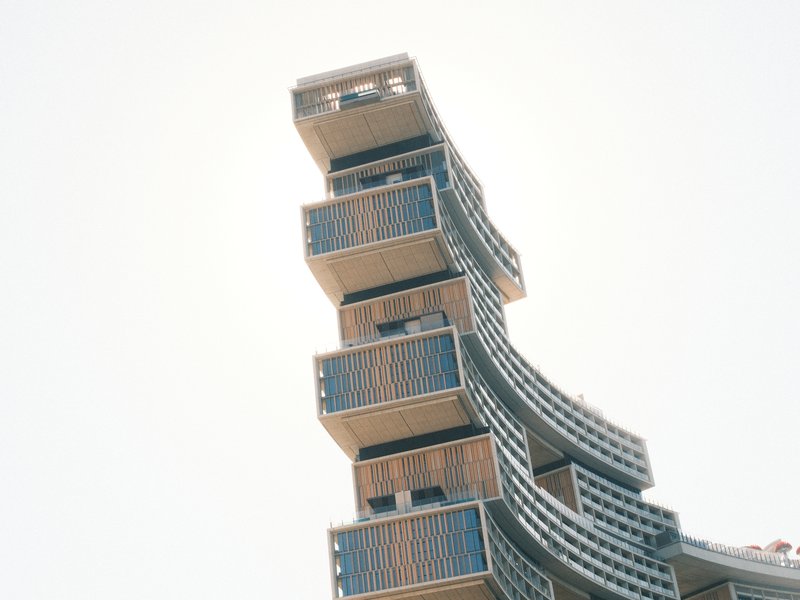 A modern architectural building with stacked, cantilevered sections against a clear sky.