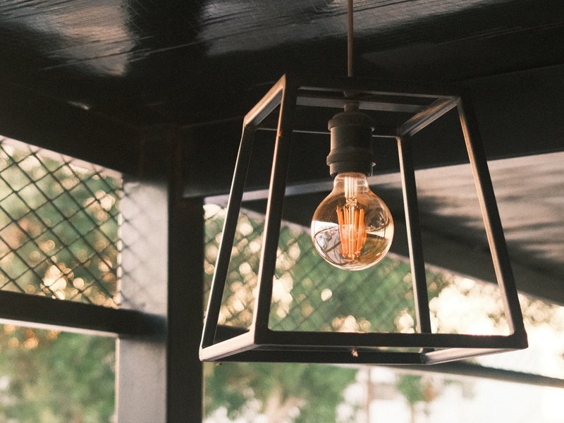 A pendant light fixture with a vintage bulb hanging in a cozy indoor setting.