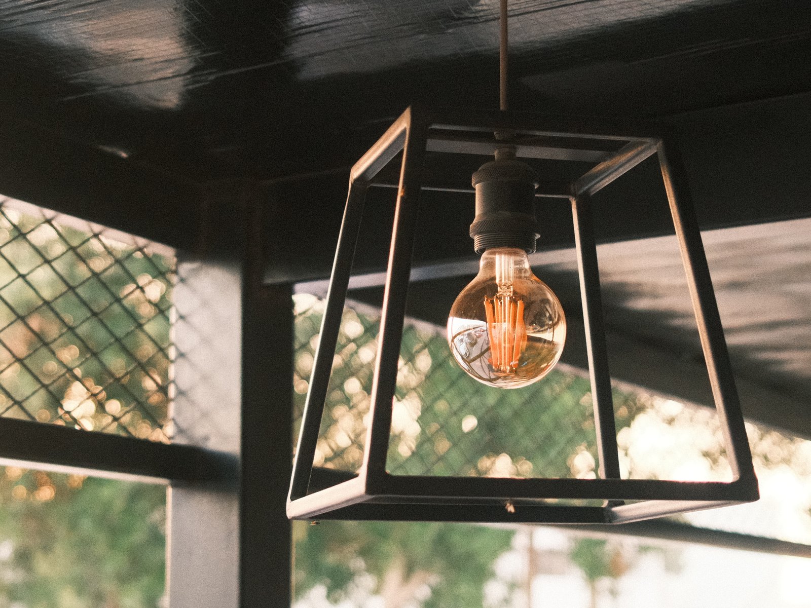 A pendant light fixture with a vintage bulb hanging in a cozy indoor setting.