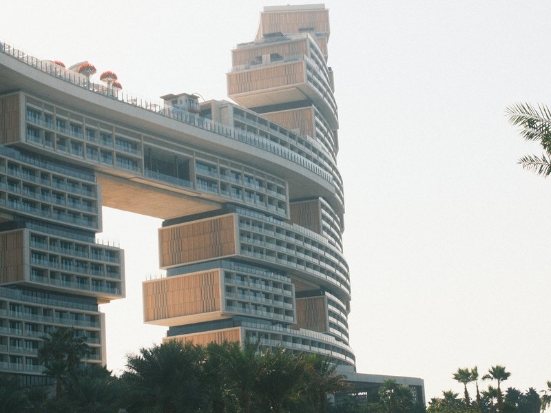 Modern architectural structure with unique design and palm trees in the foreground.