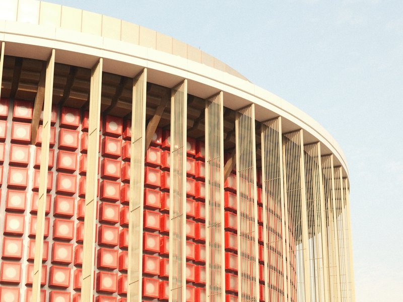 Close-up of a modern architectural building with a curved facade and red paneling.