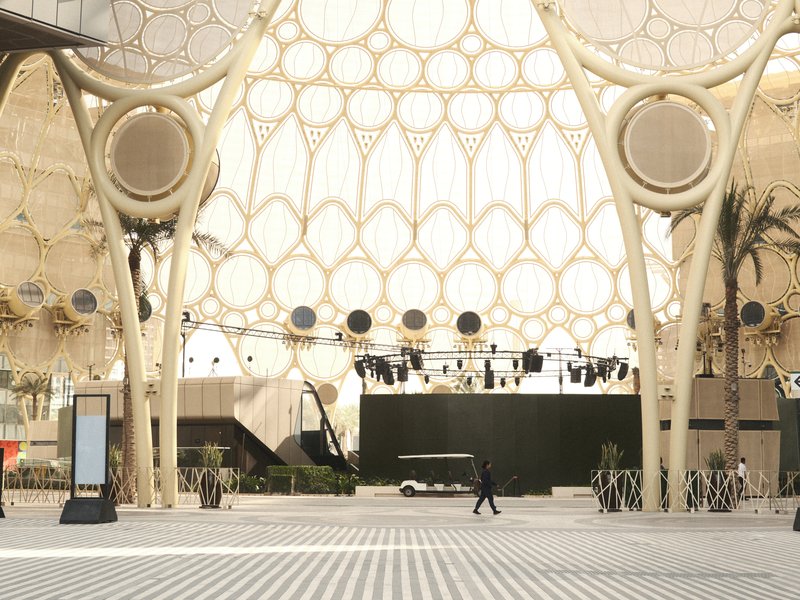 A spacious indoor area with unique architectural features and a lone figure walking through.
