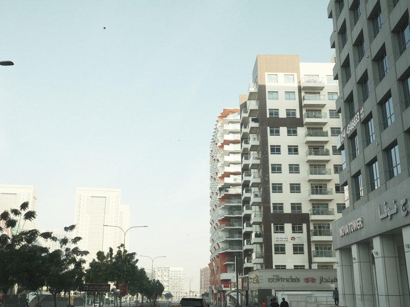 Urban street scene with modern buildings and clear sky.