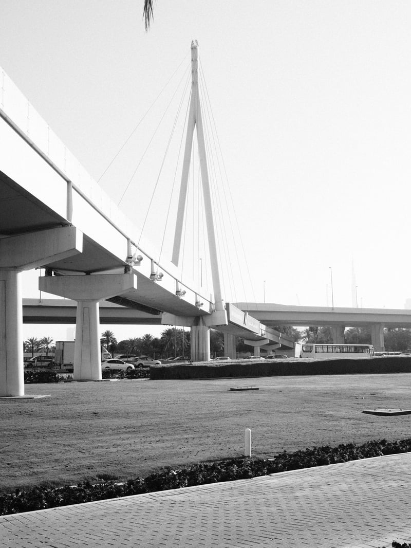 A modern bridge with a tall, white support structure against a clear sky.