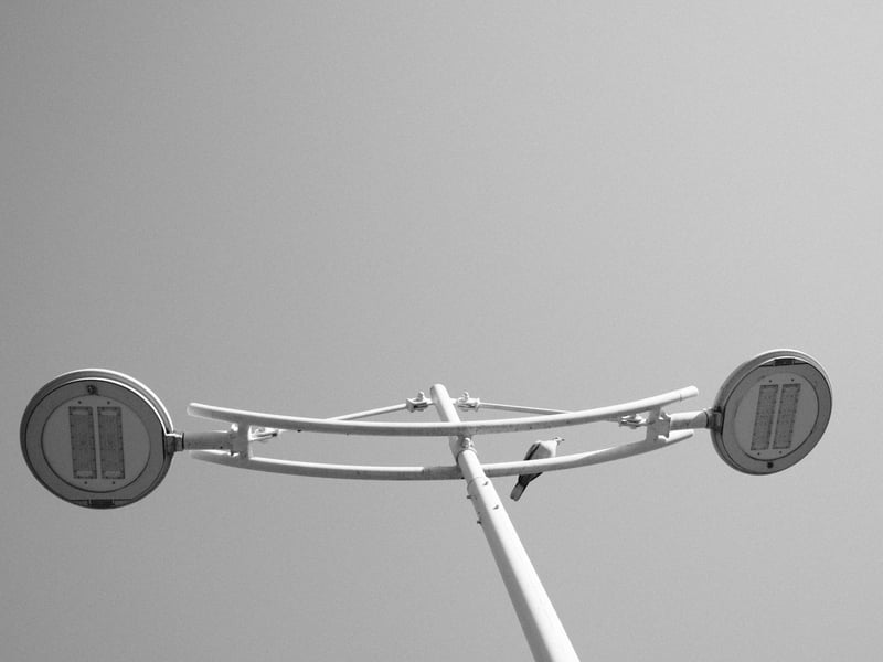 Low-angle view of a modern street lamp against a clear sky.