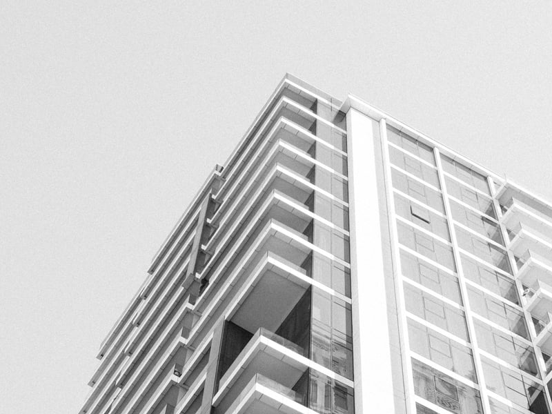 A modern high-rise building with a geometric design against a clear sky.