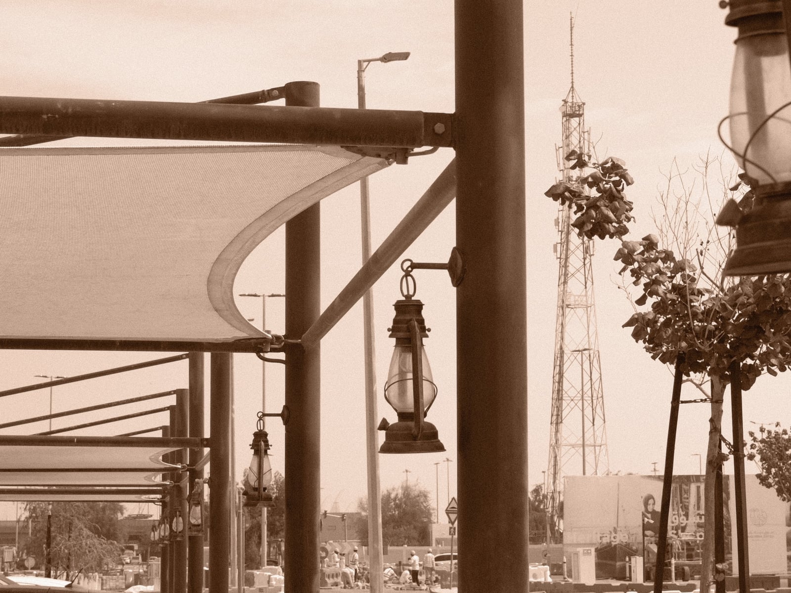 A vintage lantern hanging under a canopy with a tower in the background, creating a nostalgic atmosphere.