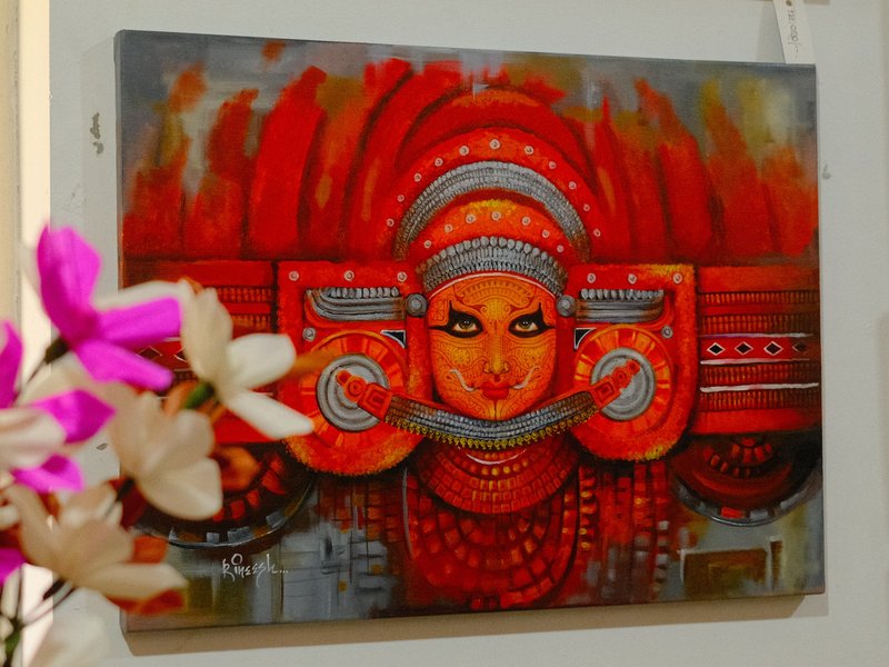 A vibrant painting of a deity with a red and orange color palette, adorned with intricate details.
