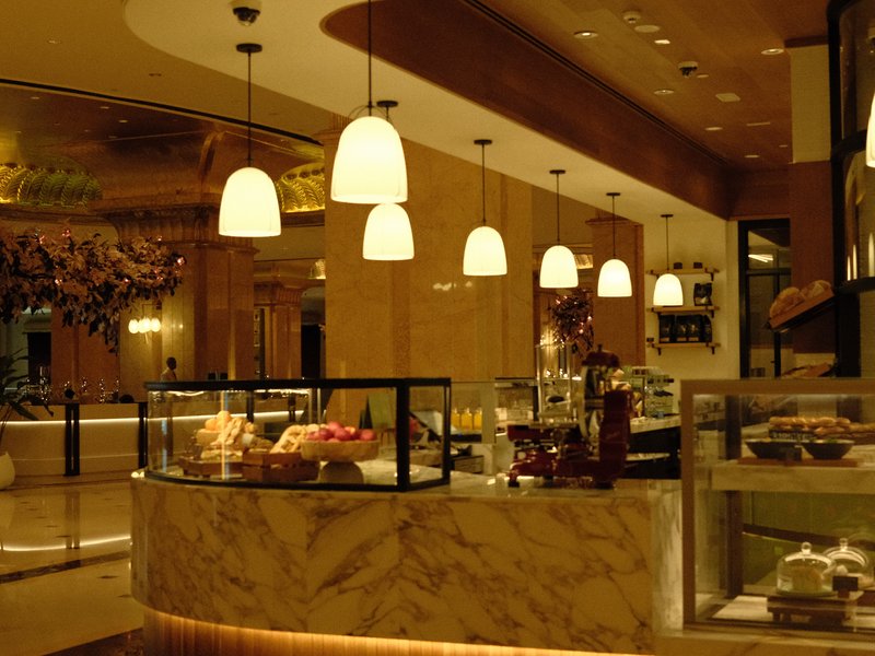 Interior of a cozy bakery with soft lighting and display cases filled with pastries.