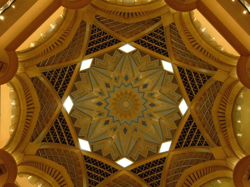 Intricate ceiling design featuring geometric patterns and warm lighting.