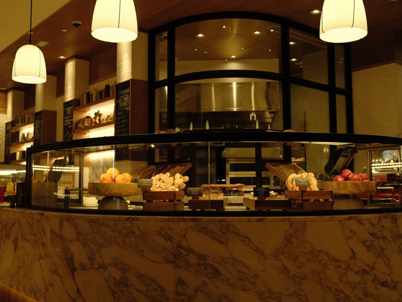 Interior view of a modern dessert counter with various pastries and desserts displayed under glass.