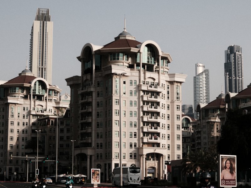 Urban skyline featuring modern buildings with a mix of architectural styles under a clear sky.