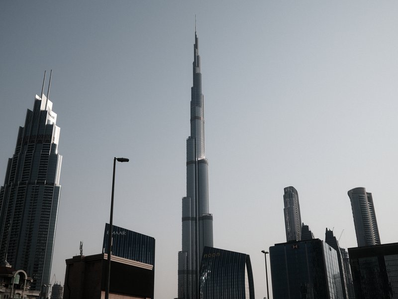 Silhouetted skyscrapers against a clear sky, featuring the Burj Khalifa prominently in the center.