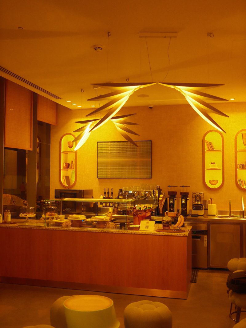 Interior view of a cozy cafe with warm lighting and modern decor.